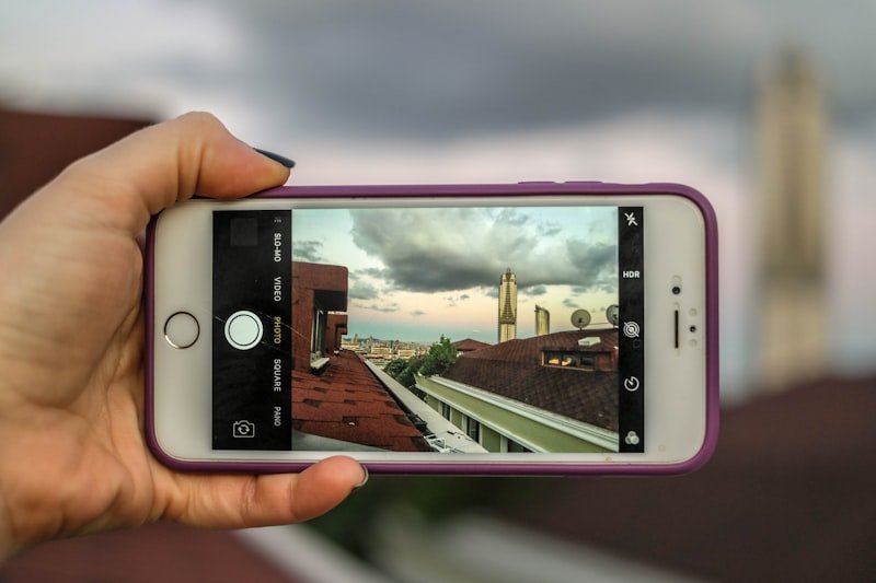 person holding silver iphone 6 with purple case