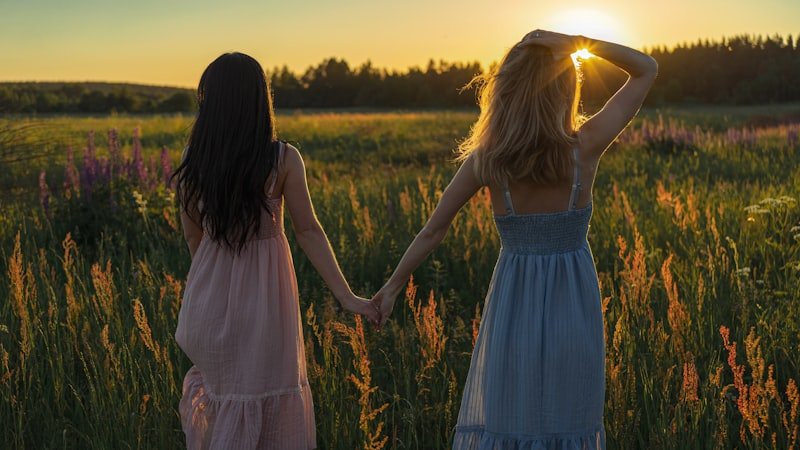 woman in white and pink dress standing on brown grass field during daytime
