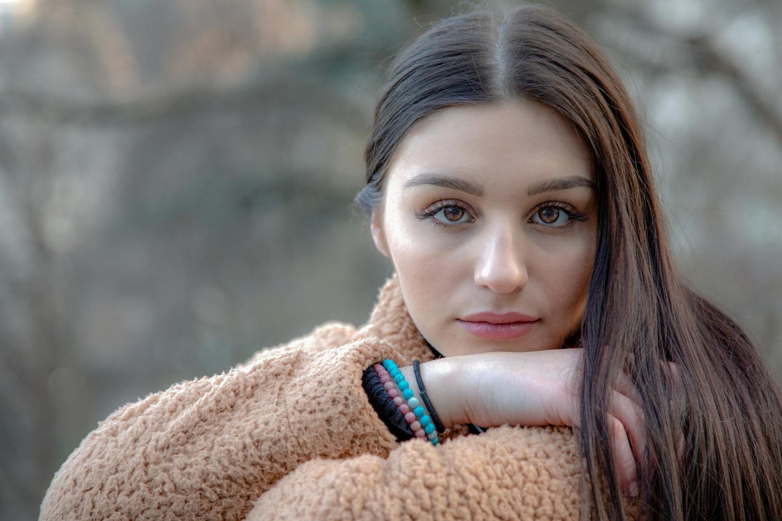 Close-up of a young woman with long hair in a cozy jacket, exploring New York City outdoors.