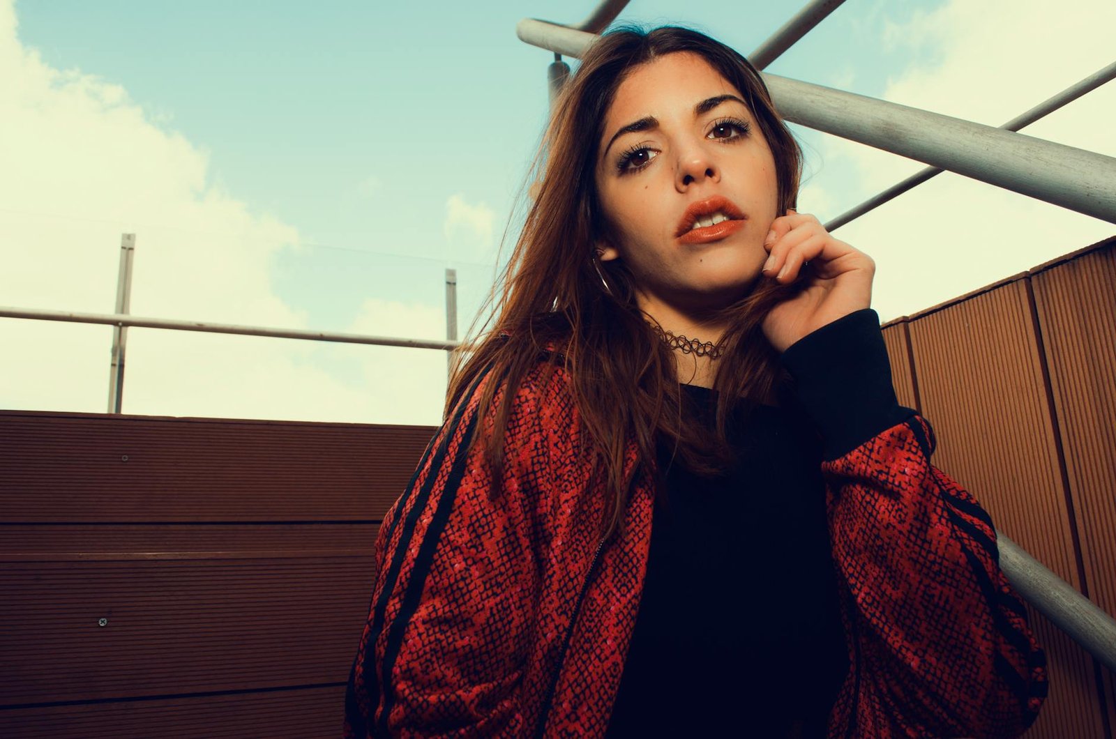 Portrait of a fashionable young woman in a red jacket outdoors.