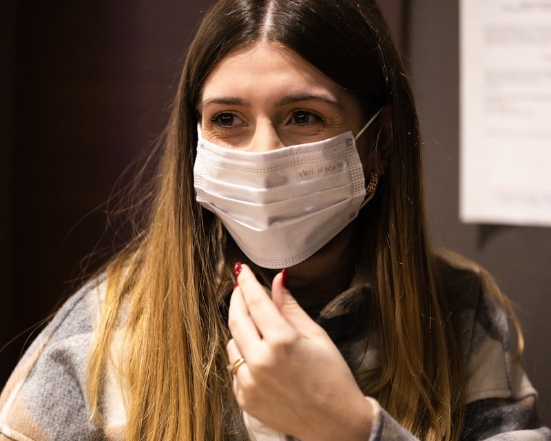 a woman wearing a face mask and looking at the camera