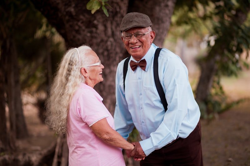 A man and woman standing next to each other near a tree