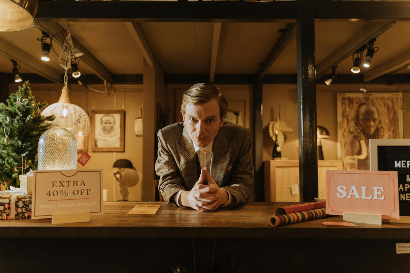 Salesman in a shop offering discounts and sales promotions with 40% off signs.