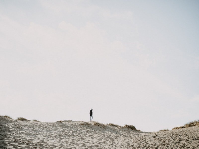 a person standing on top of a sandy hill