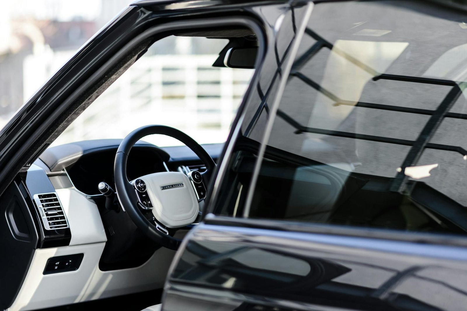 Close-up view of a luxury car interior highlighting the elegant steering wheel and dashboard design.
