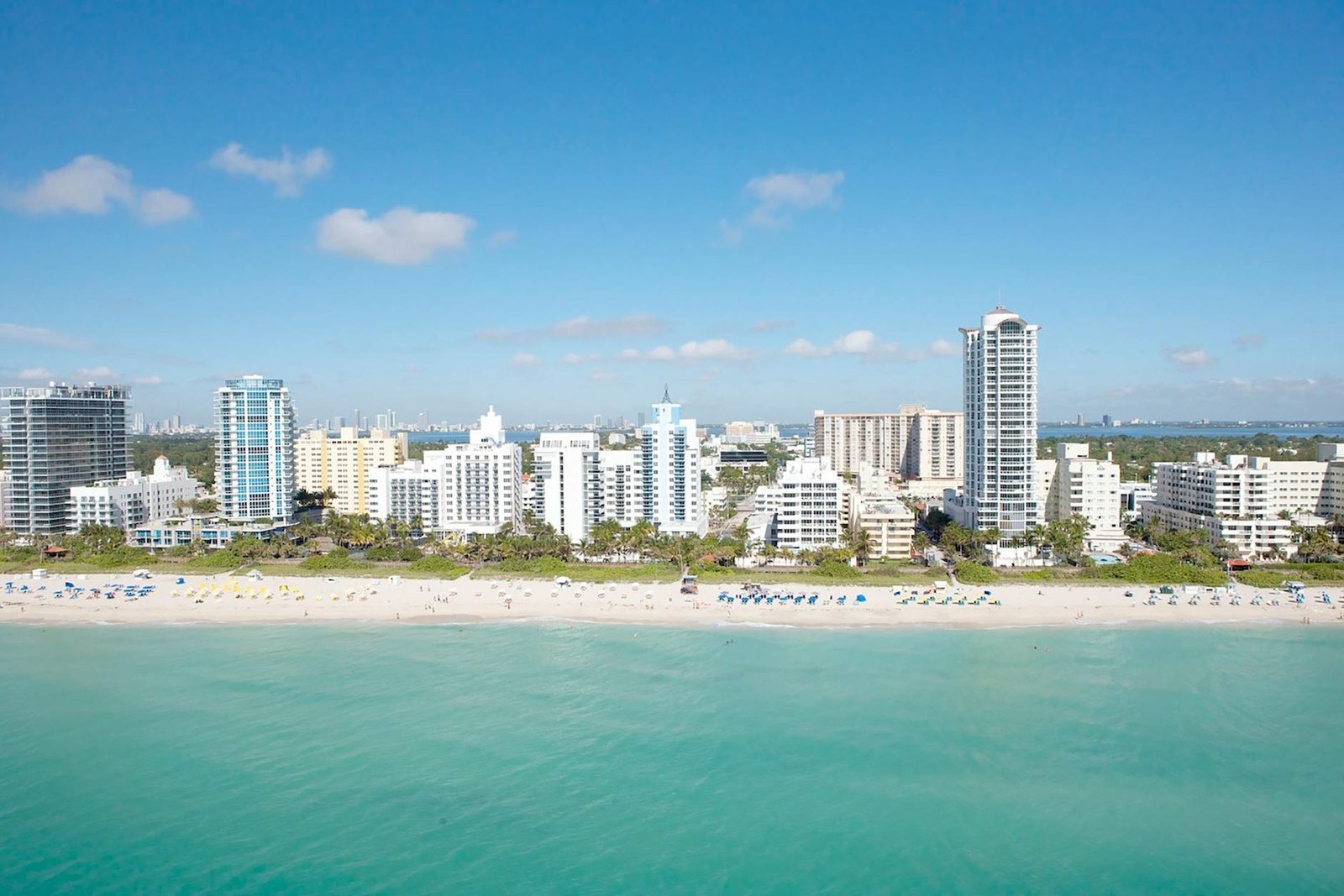 Stunning aerial view capturing the Miami Beach skyline and its pristine coastline under a clear blue sky.