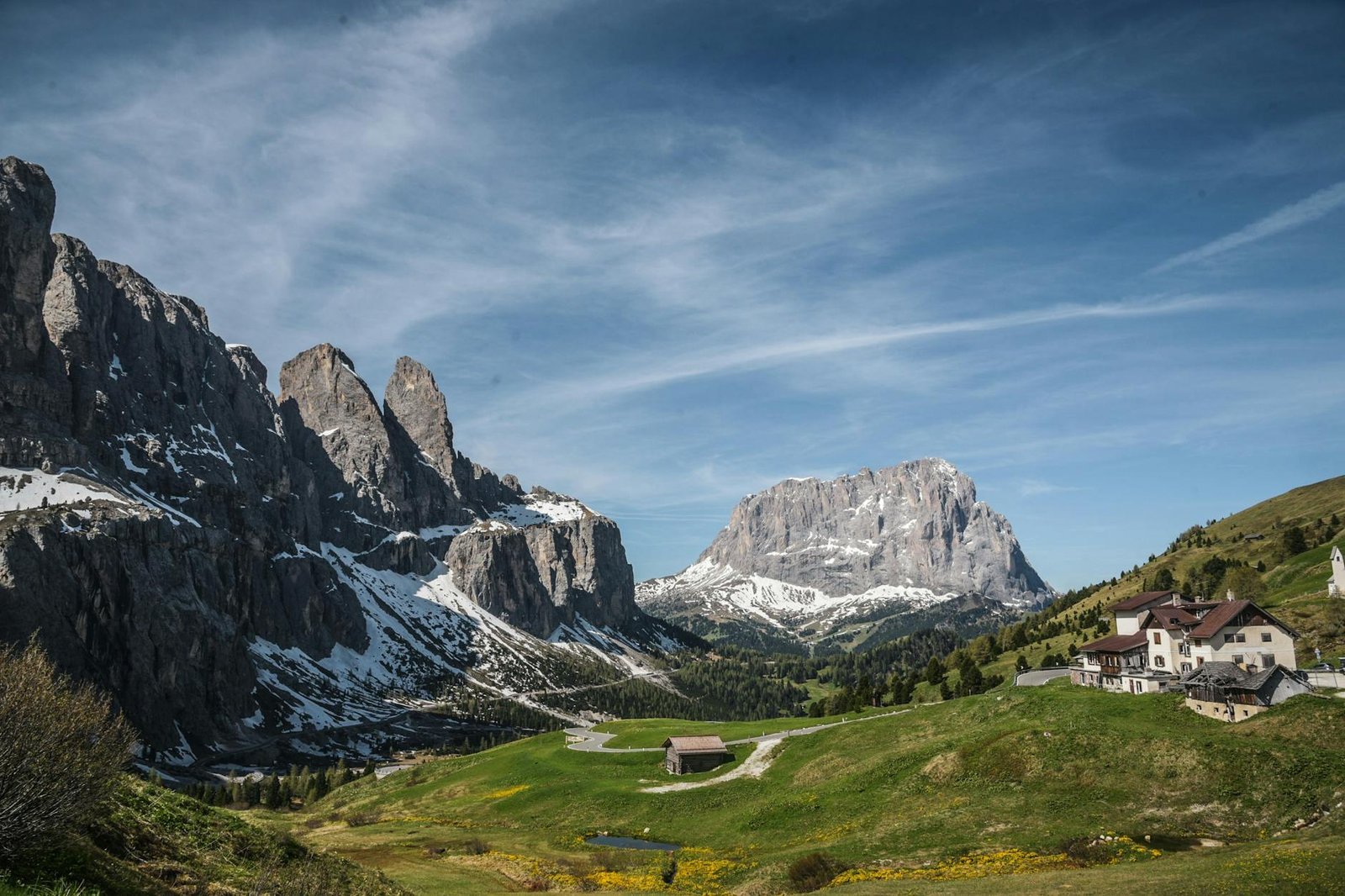 Breathtaking view of the Dolomites with scattered houses and lush greenery in Trentino-South Tyrol, Italy.