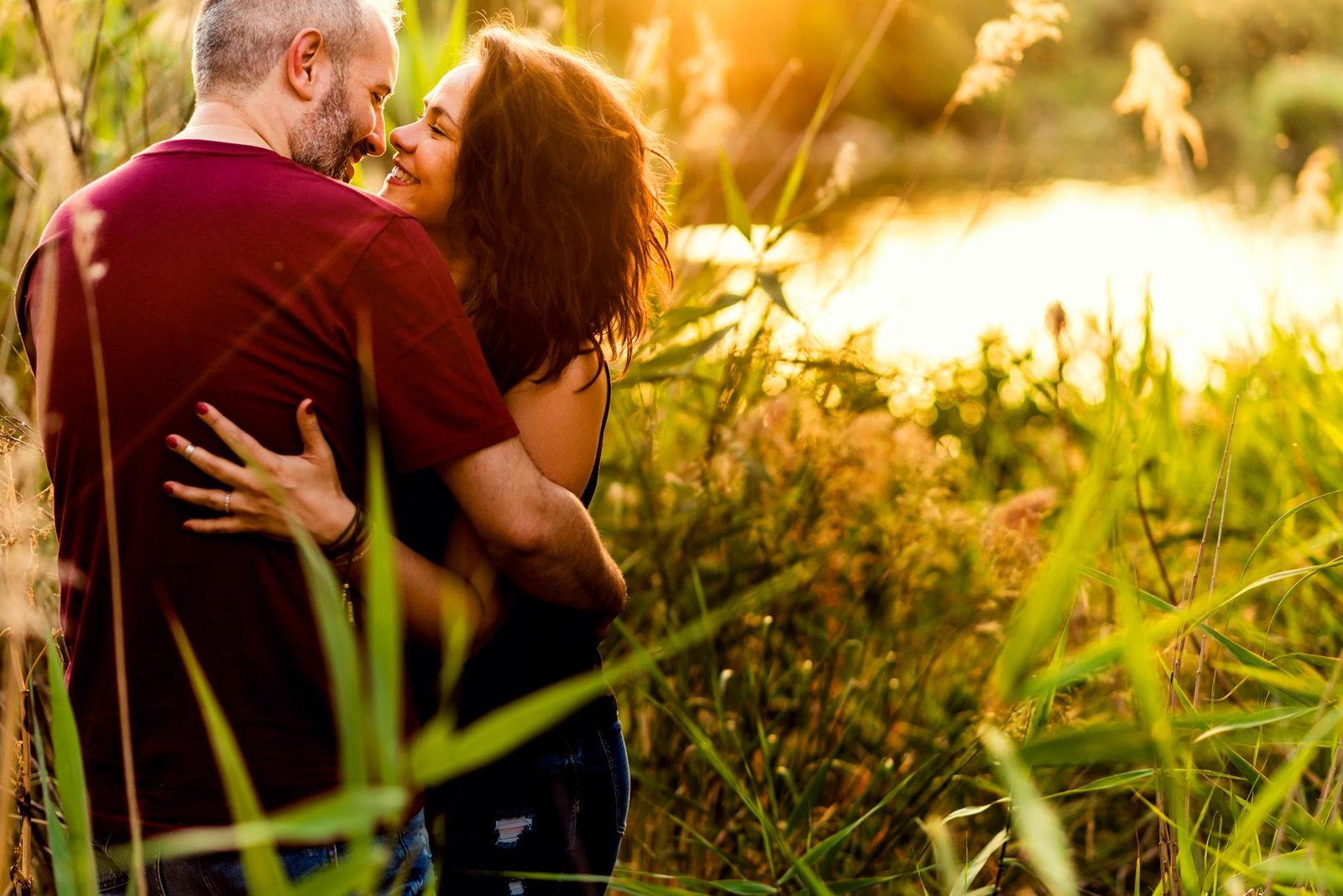 A couple embracing in a sunlit meadow, capturing love and intimacy in nature.