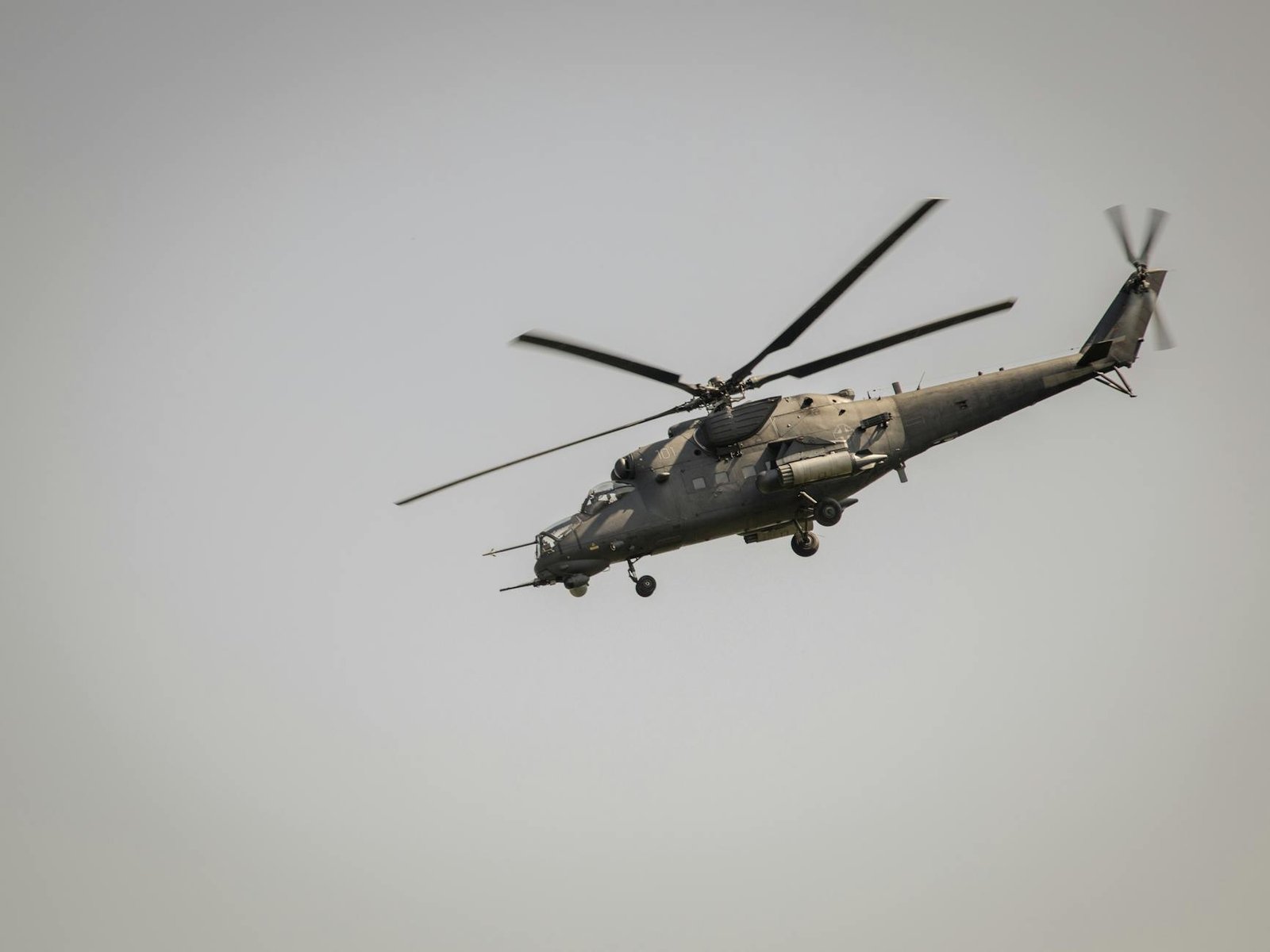 A military helicopter flying at a low angle against a clear sky in Belgrade, Serbia.