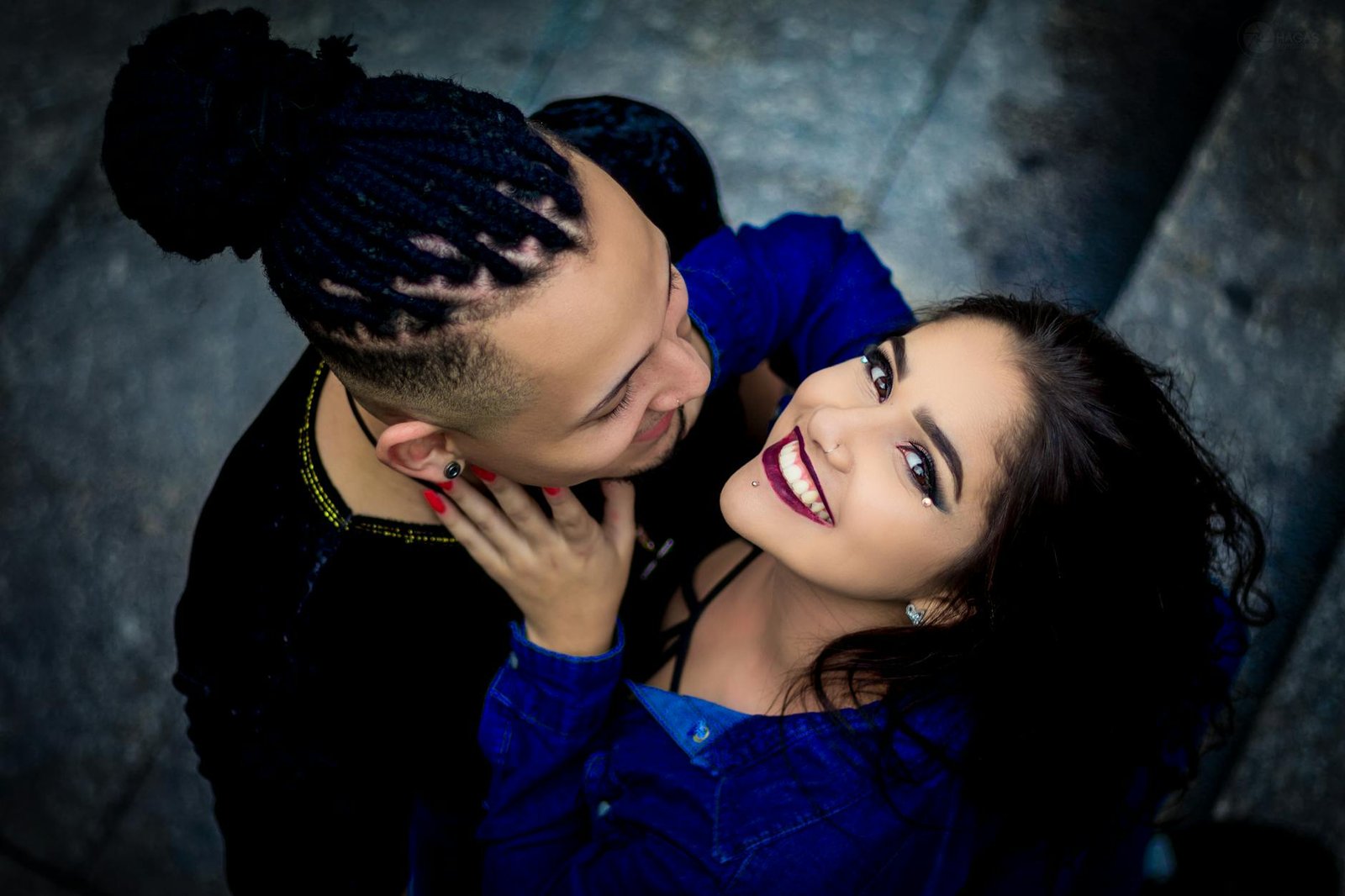 High angle view of a smiling couple in an affectionate embrace on a city street.