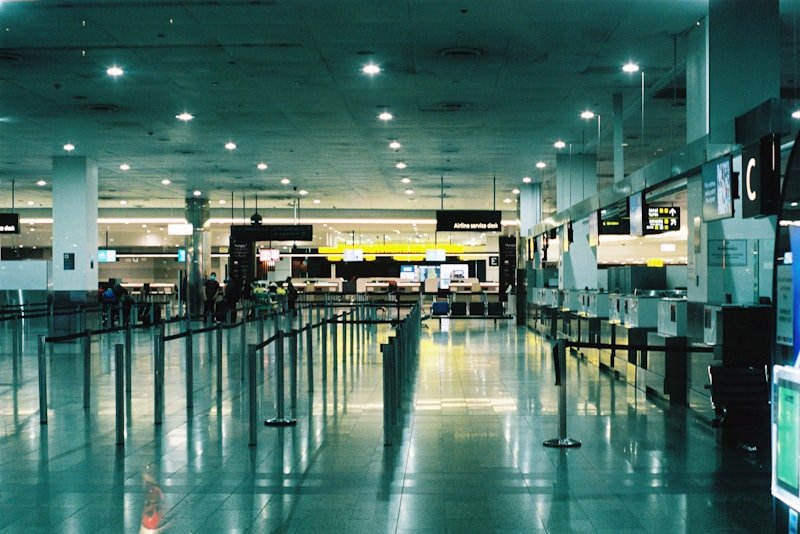 an empty airport terminal with people walking through it