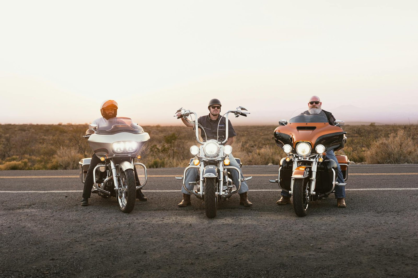 Three bikers on motorcycles on Route 66 at sunset, New Mexico desert.