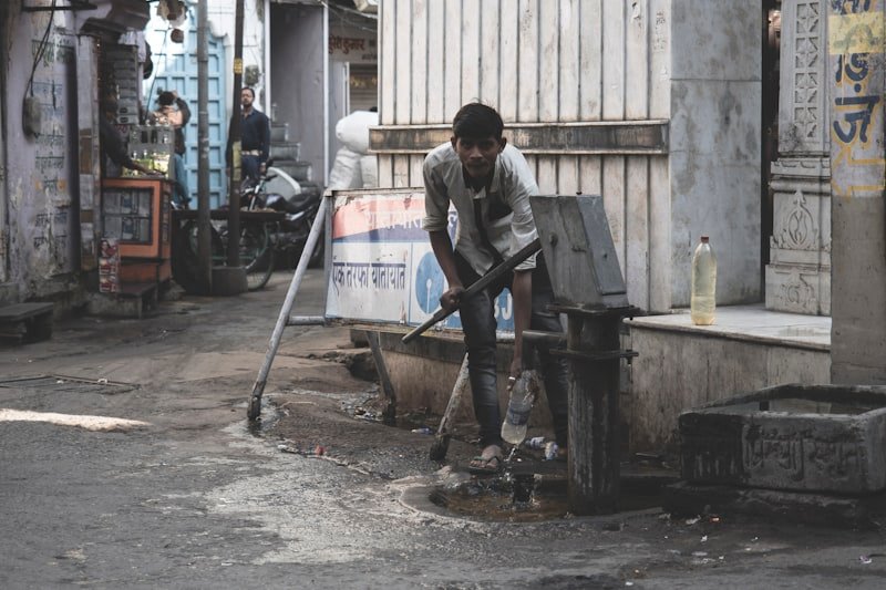 man pumping water on water pump