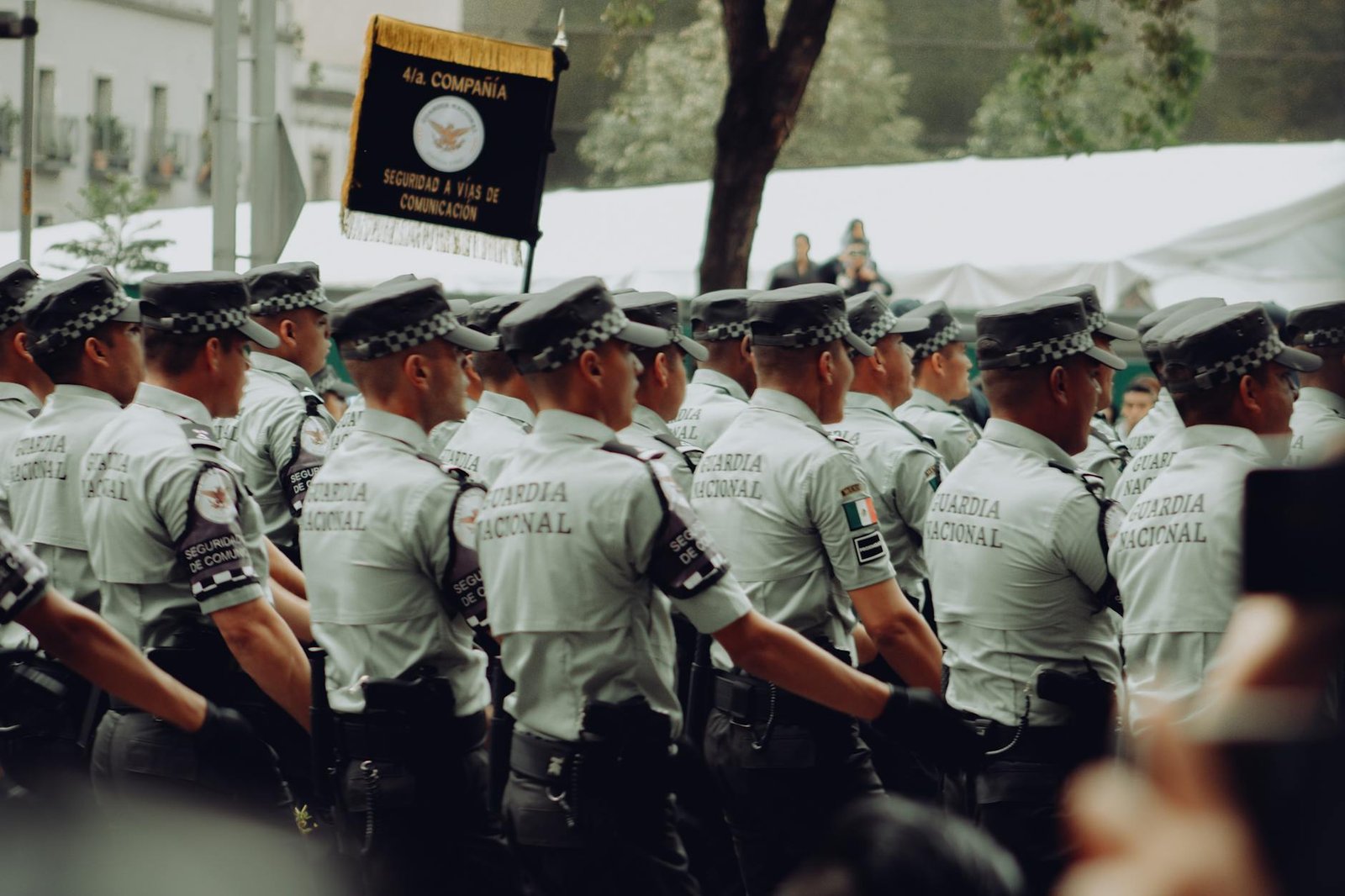 A group of uniformed National Guard soldiers marching in formation during a parade.
