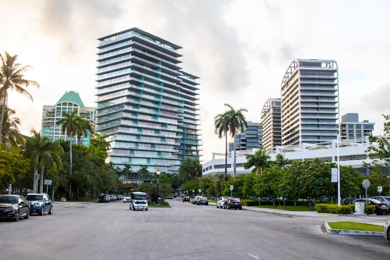 A city street lined with tall buildings and palm trees