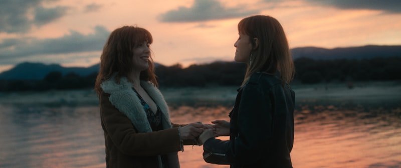 two women sitting on a beach