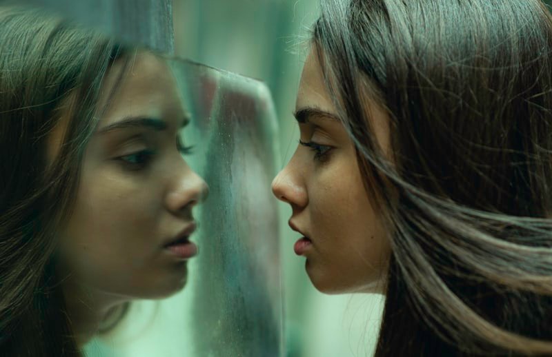 two girls looking at each other in a mirror