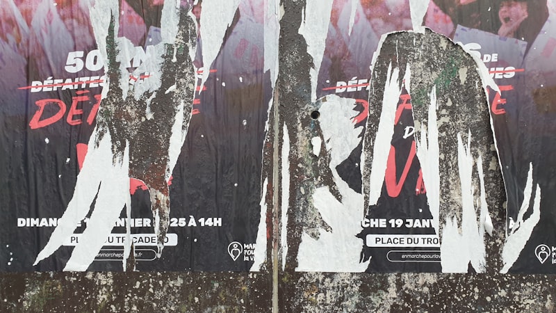 A bunch of posters on the side of a building